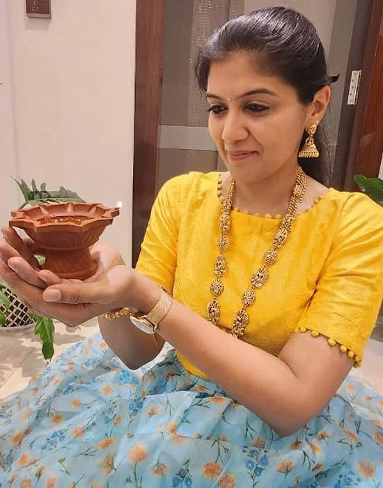 Dr. Sneha holding a clay diya